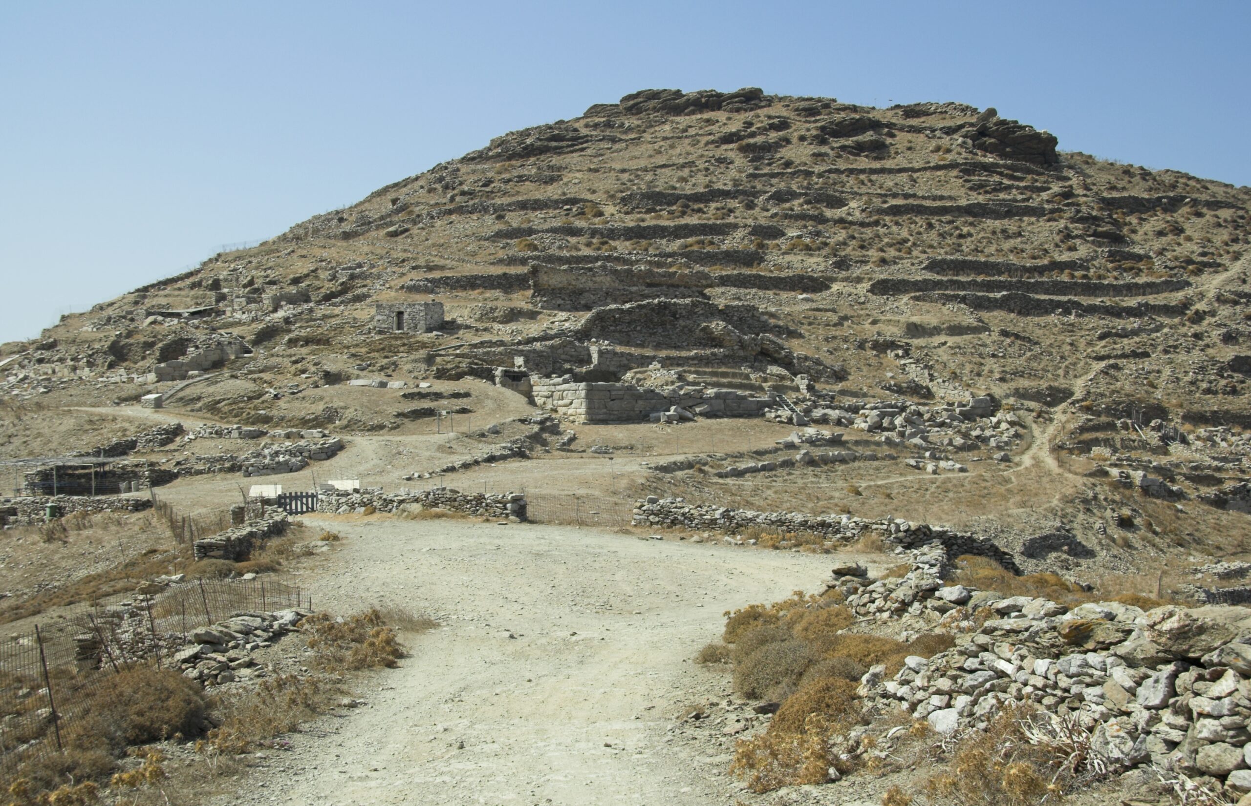 Crystal clear waters and rugged cliffs at Amorgos with ancient fort ruins visible