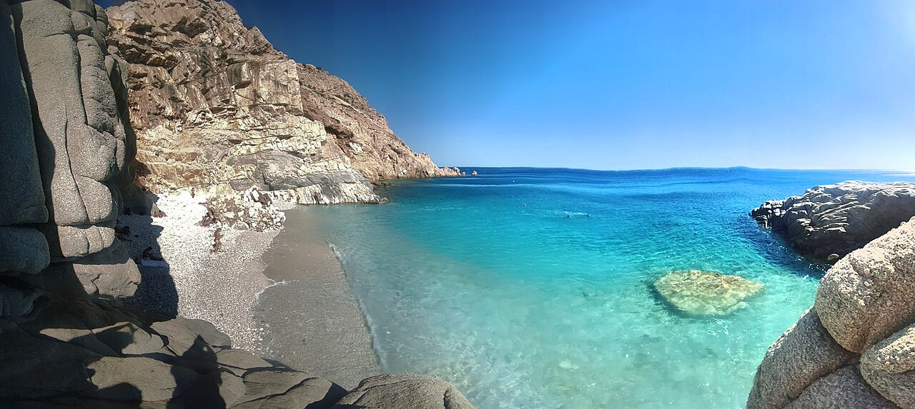 Seychelles Beach on Ikaria — a dramatic cove of white pebbles and turquoise water framed by sheer cliffs