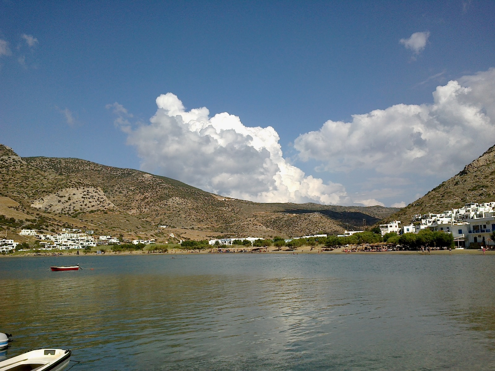 Kamares port village, Sifnos, with the bay, whitewashed buildings and mountains behind