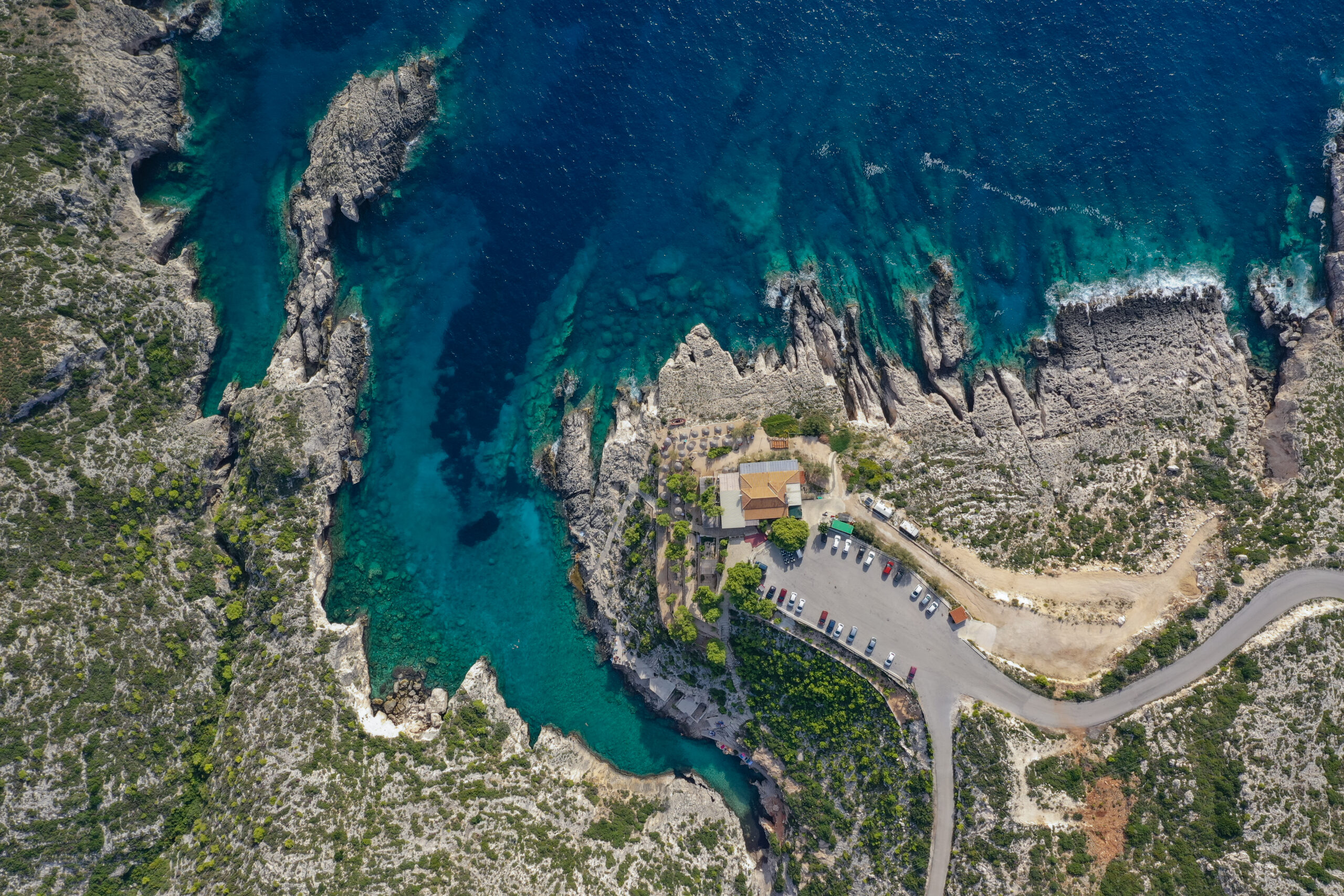 Aerial view of Porto Limnionas cove with dramatic limestone cliffs and crystal clear turquoise water, Zakynthos, Greece