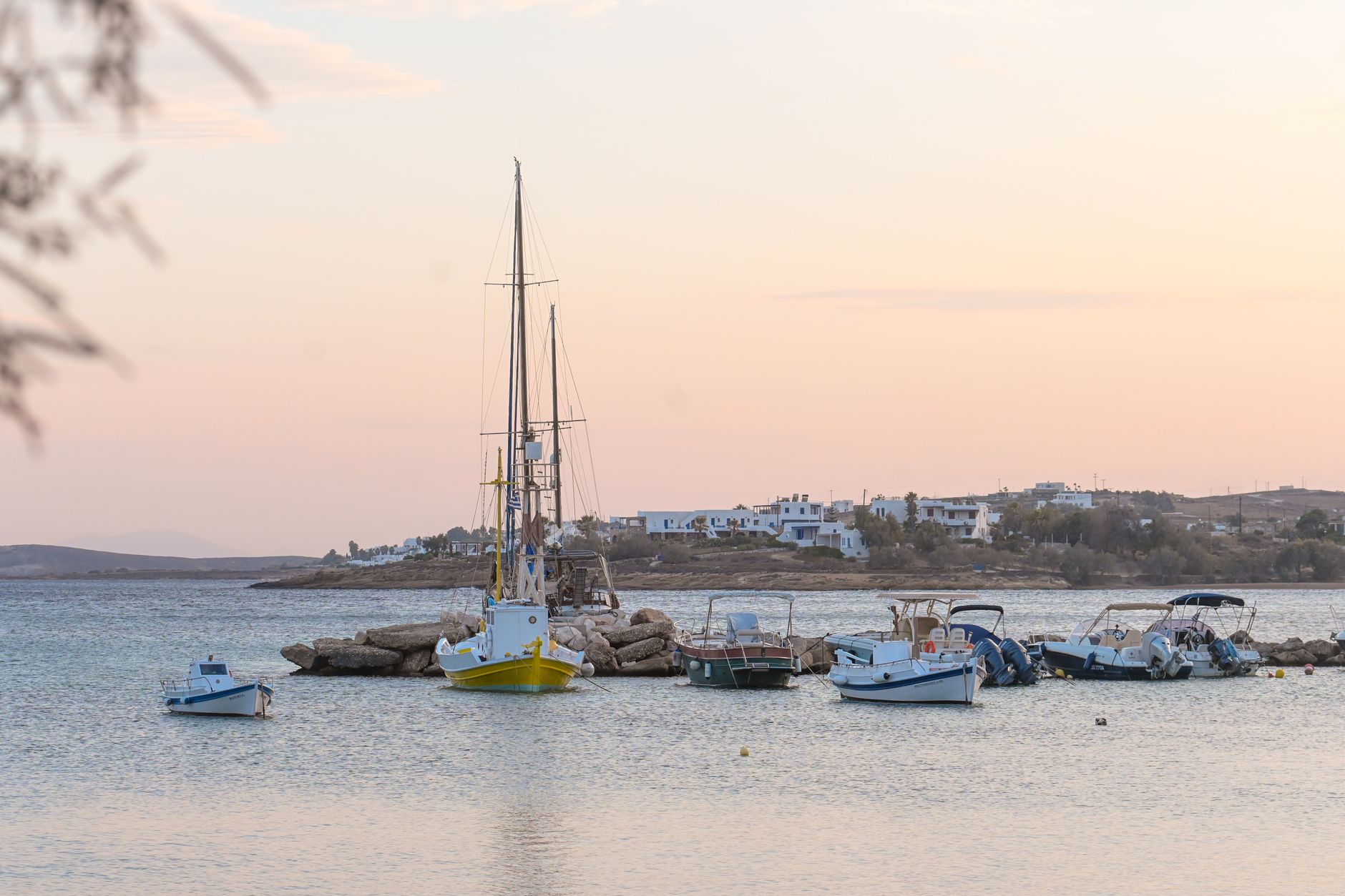 Boats moored in the calm waters of Aliki Bay at dawn, southern Paros