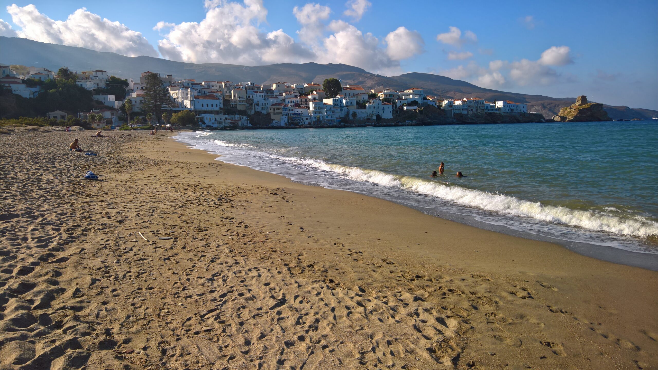 The main sandy beach at Chora Andros, Cyclades, Greece, with turquoise waters