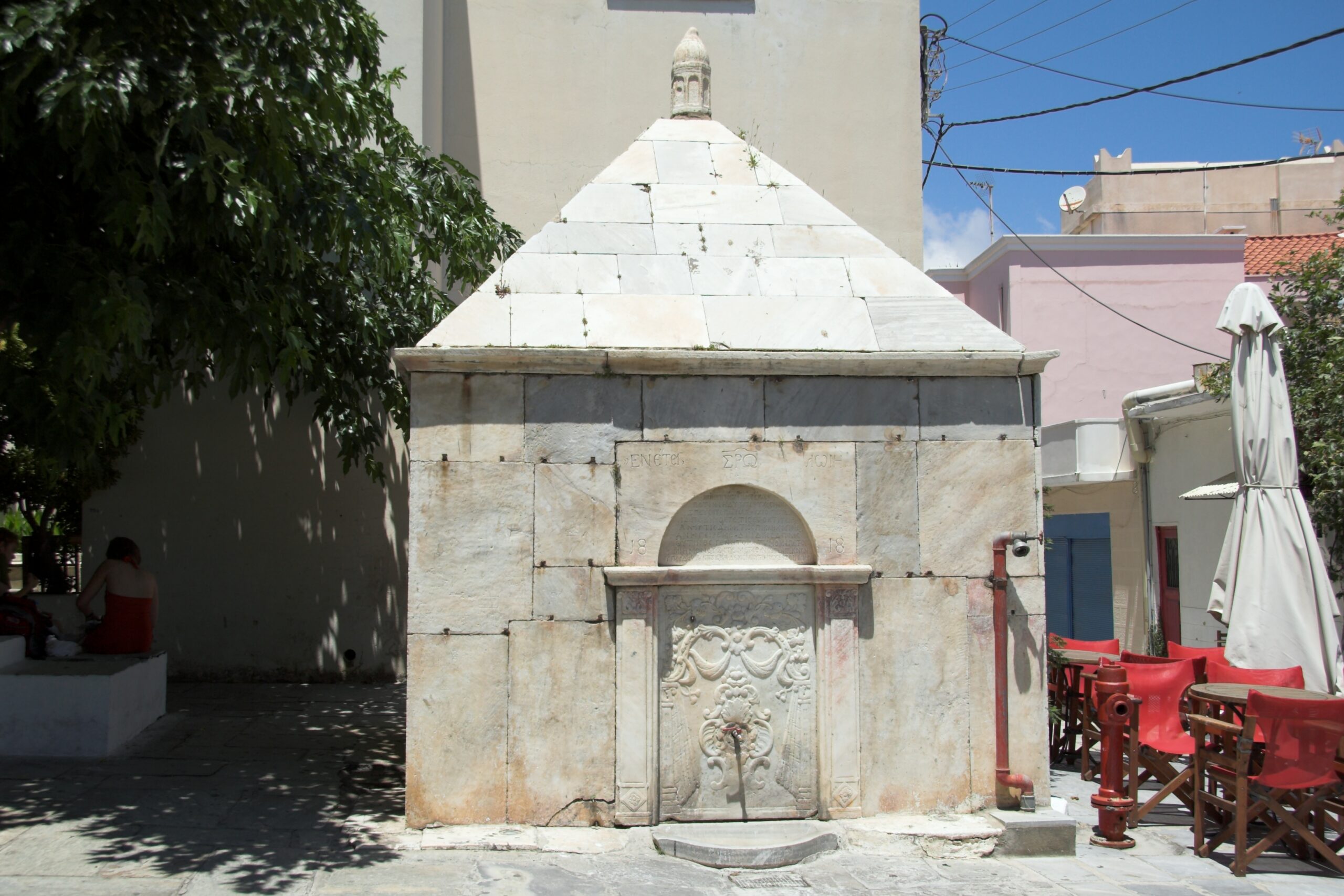 Historic marble fountain with inscriptions from 1818 in Andros town