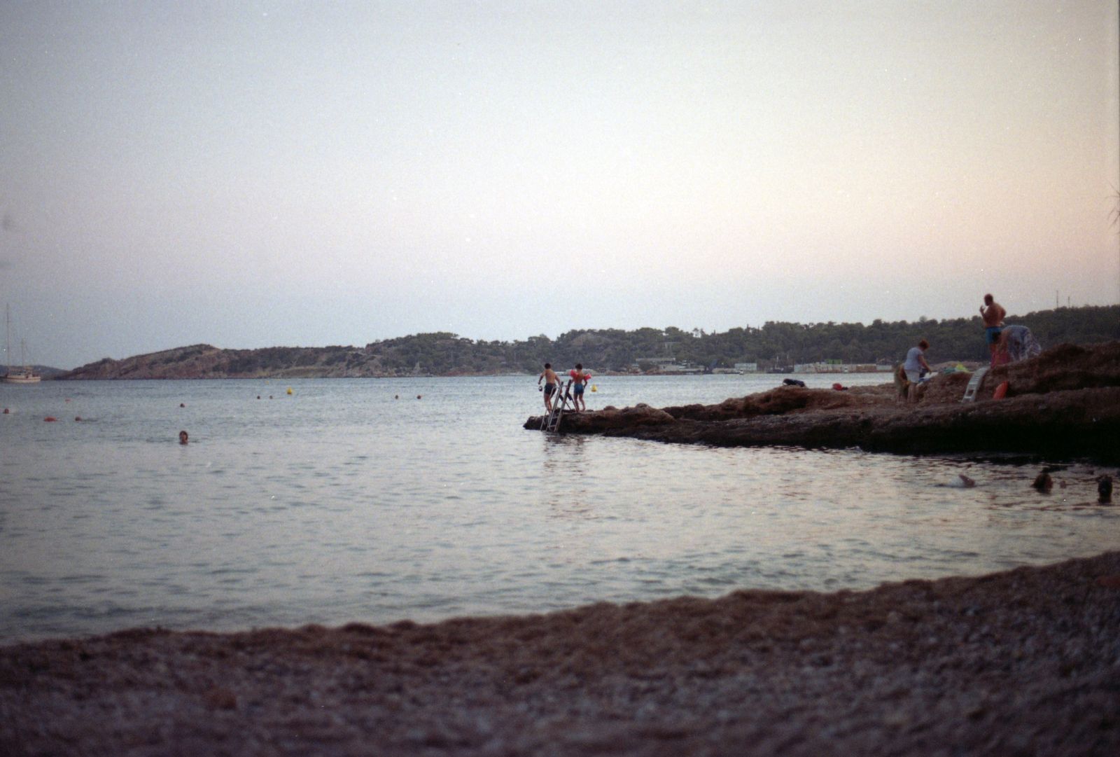 People enjoying a summer sunset by the sea along the Athens Riviera coast in Greece