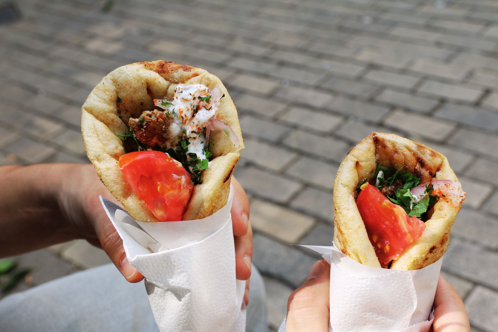 Two fresh gyros wraps filled with meat, tomato and herbs served as Greek street food in Athens
