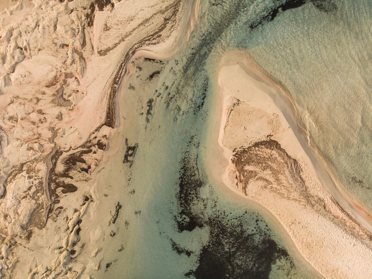 Aerial view of Elafonisi Beach in Crete showing distinctive pink-white sand formations and turquoise waters
