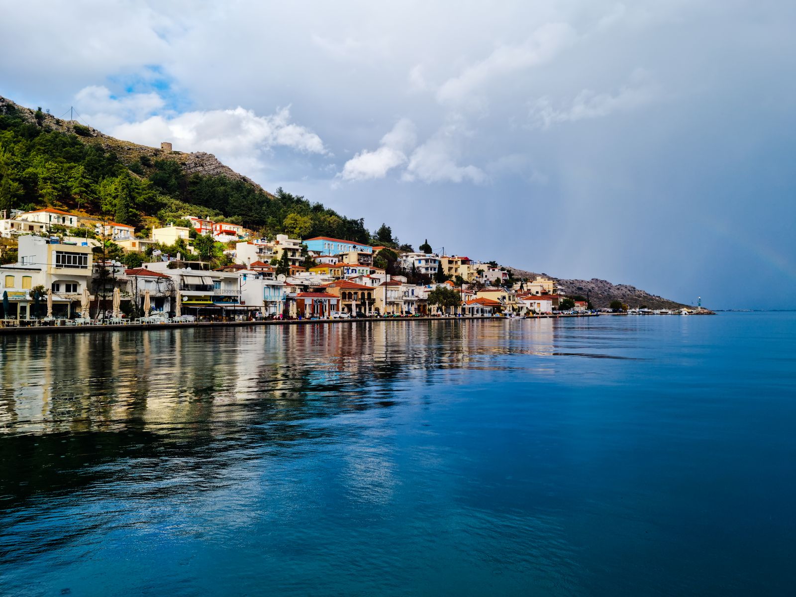 Waterfront houses reflected in calm waters at the fishing village of Lagkada, Chios