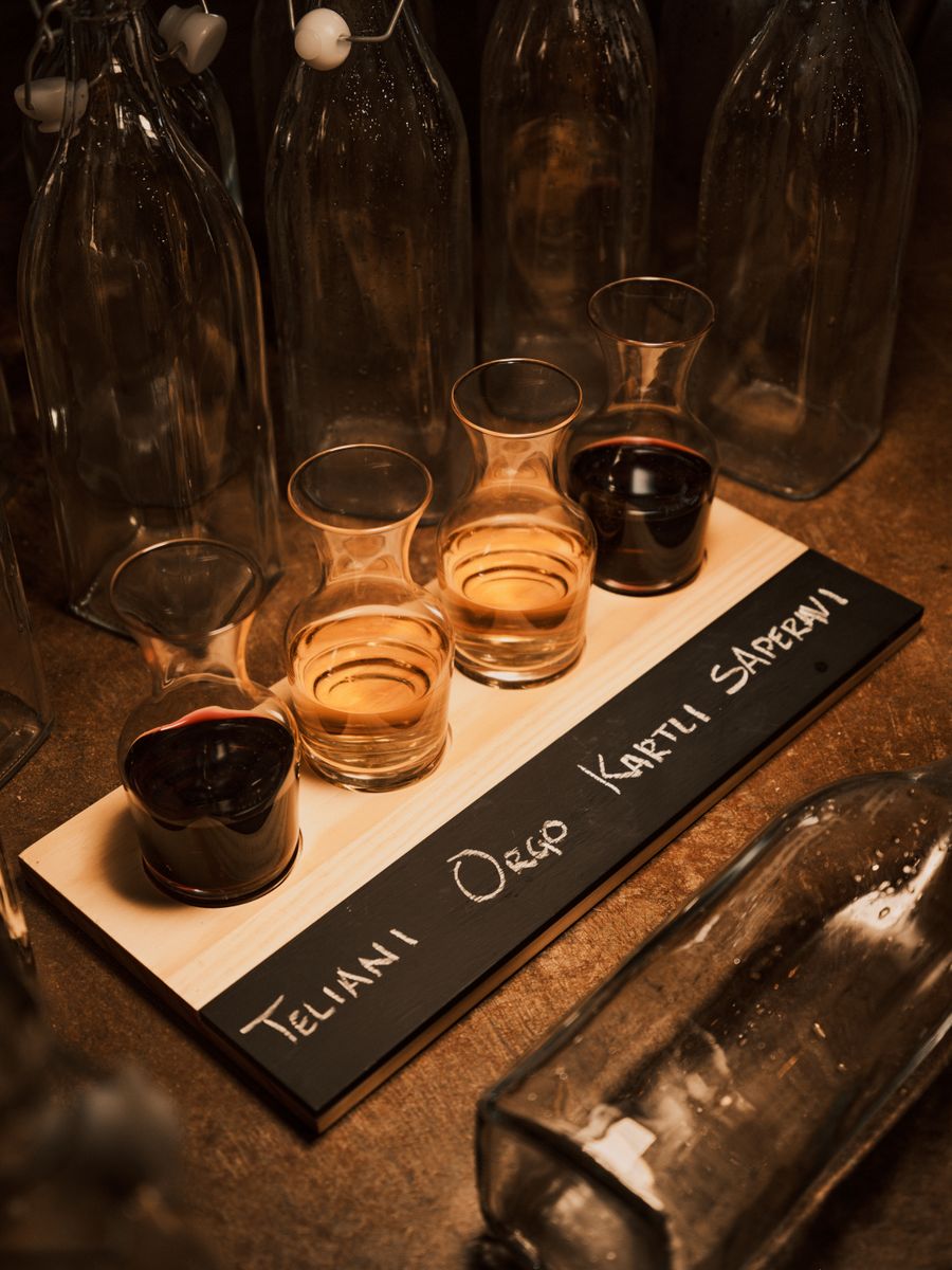 A tasting flight of Cretan wine samples in small glasses on a wooden board