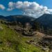 Ancient ruins at Delphi set against the mountain landscape of Central Greece under a blue sky