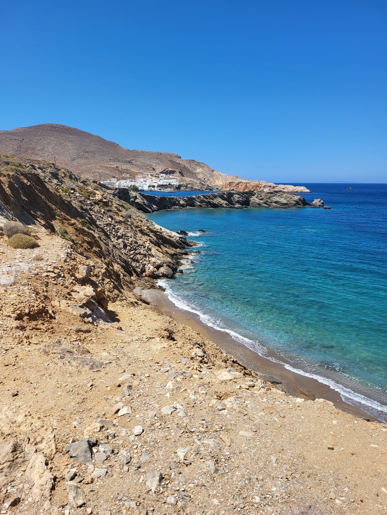 Dramatic rocky coastline and clear blue waters along the shore of Folegandros island