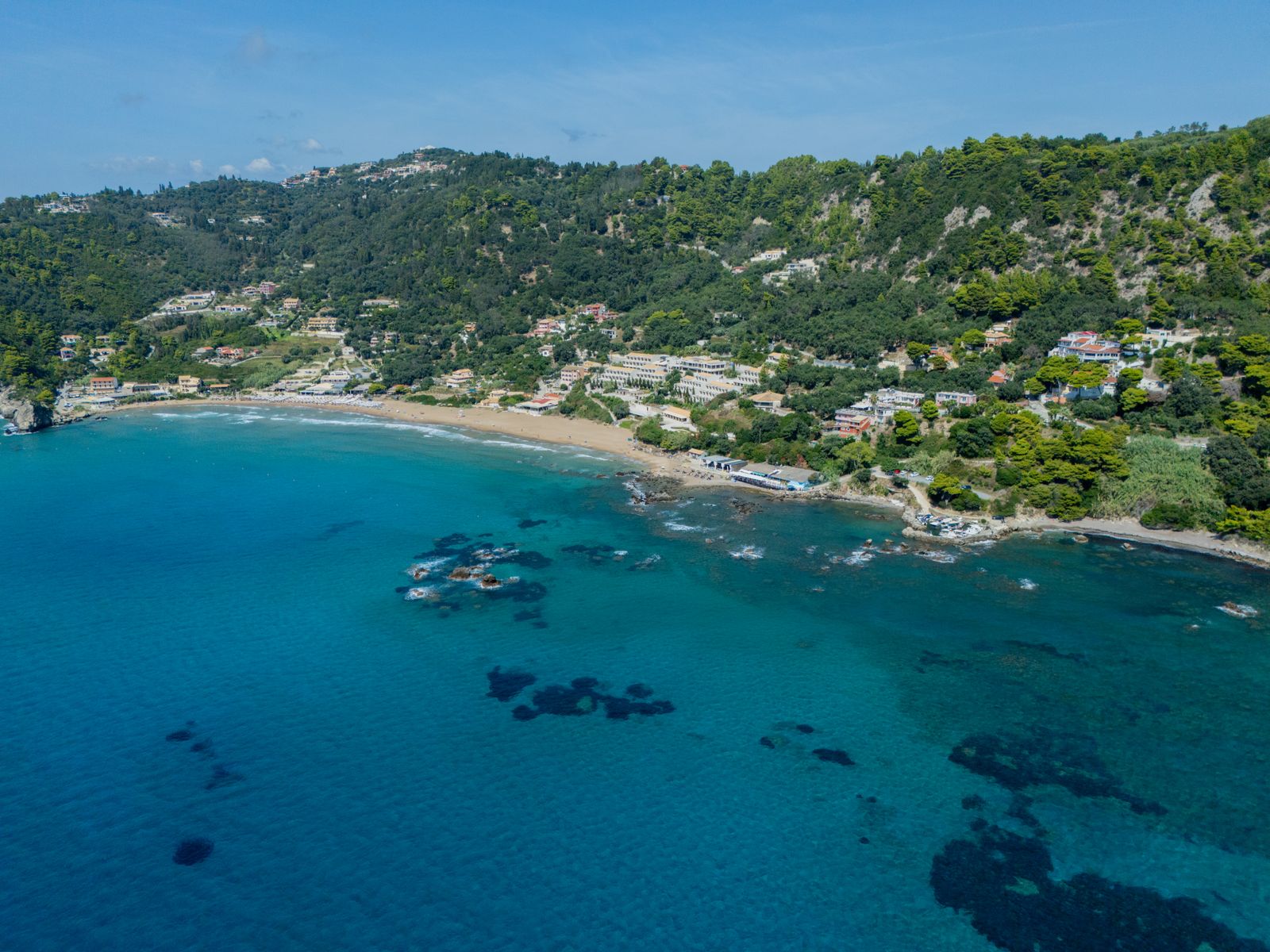 Aerial view of Glyfada beach on Corfu's west coast with golden sand and turquoise water