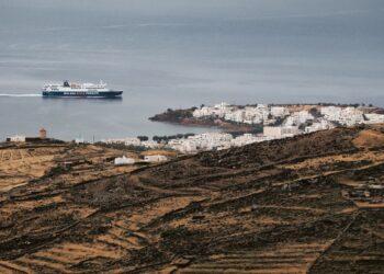 Ferry boat crossing the Aegean Sea near a Greek island village during an island-hopping trip