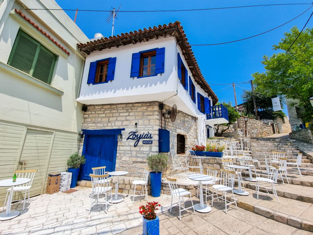 Traditional stone tavern with blue shutters in Afytos village Kassandra Halkidiki
