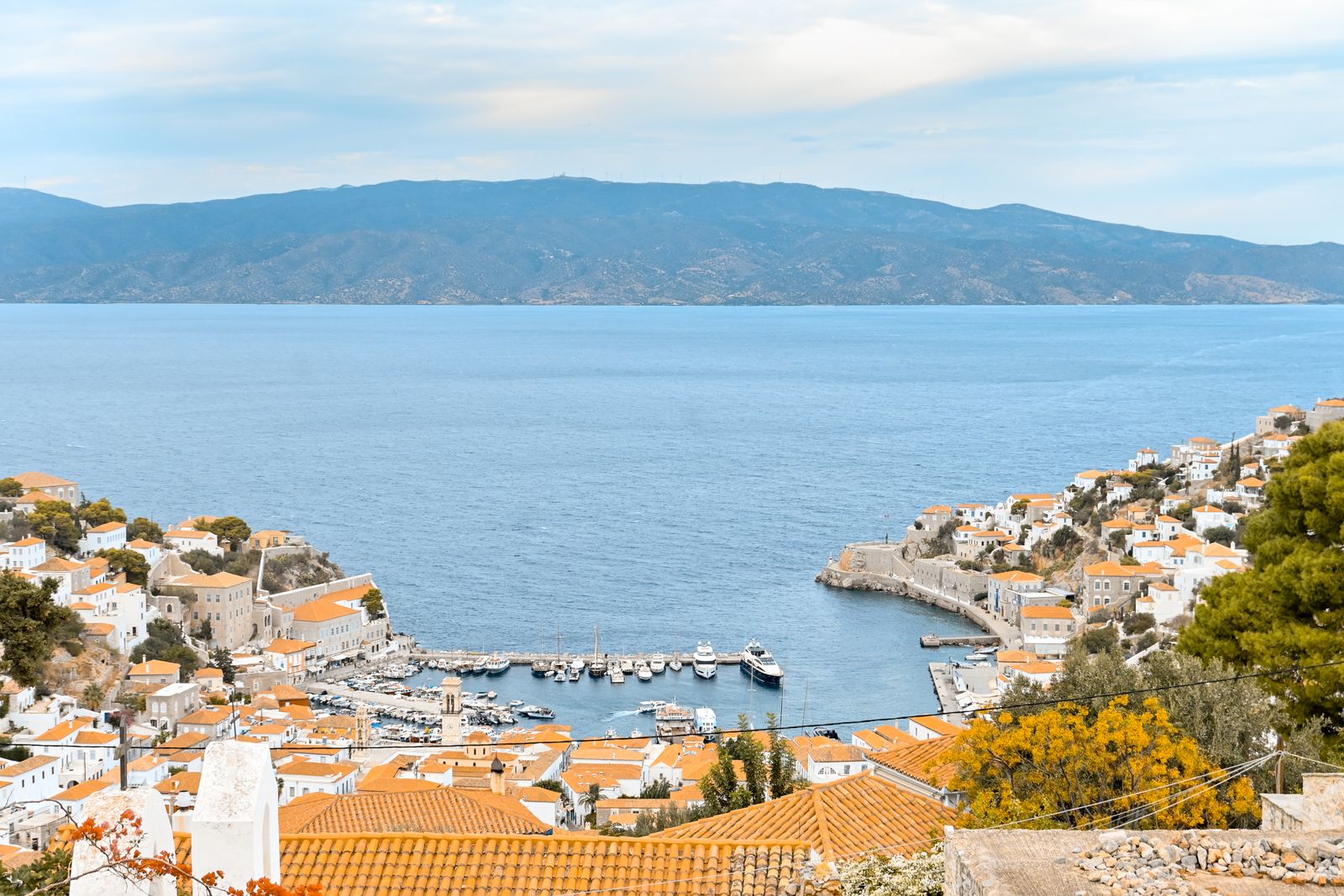 Aerial view of Hydra harbour and town showing the horseshoe-shaped port and amphitheatre of stone buildings