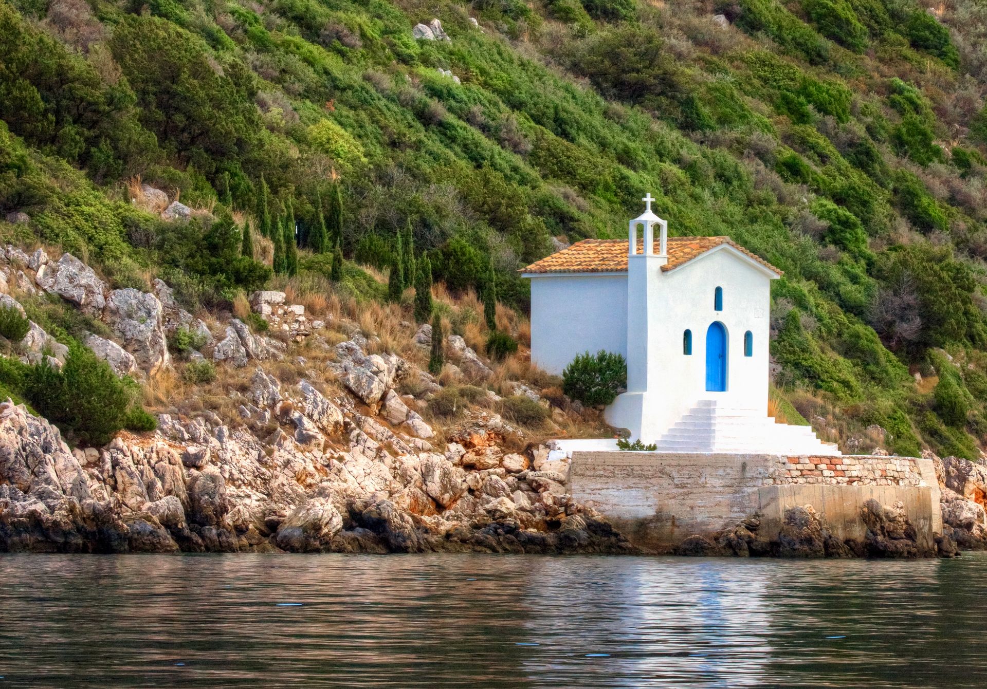 Small chapel perched on the rocky coastline of Ithaca island in the Ionian Sea Greece