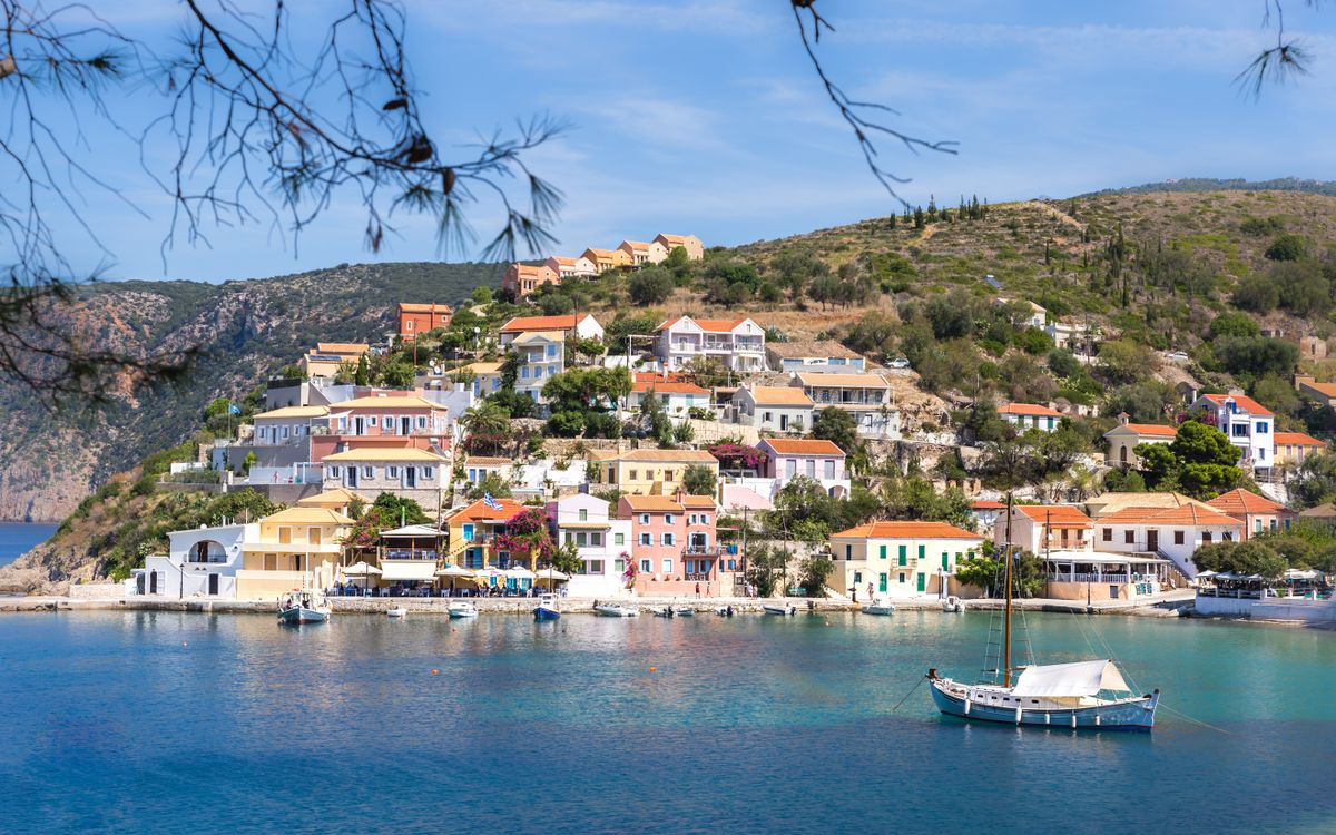 Pastel-coloured traditional houses of Assos village set among green hills in Kefalonia, Greece