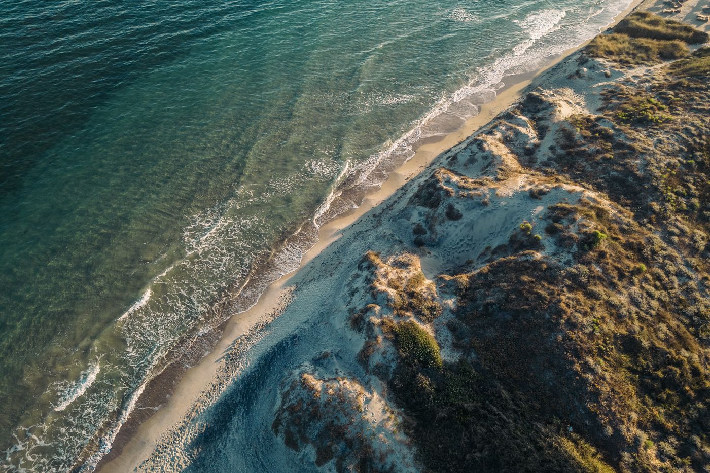 Aerial view of a sandy beach and turquoise waters along the coast of Kos island