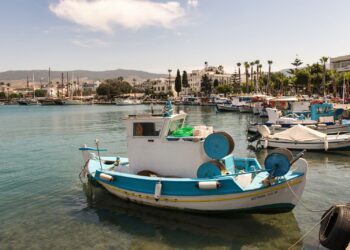 Fishing boats moored in the harbour of Kos Town with waterfront buildings in the background