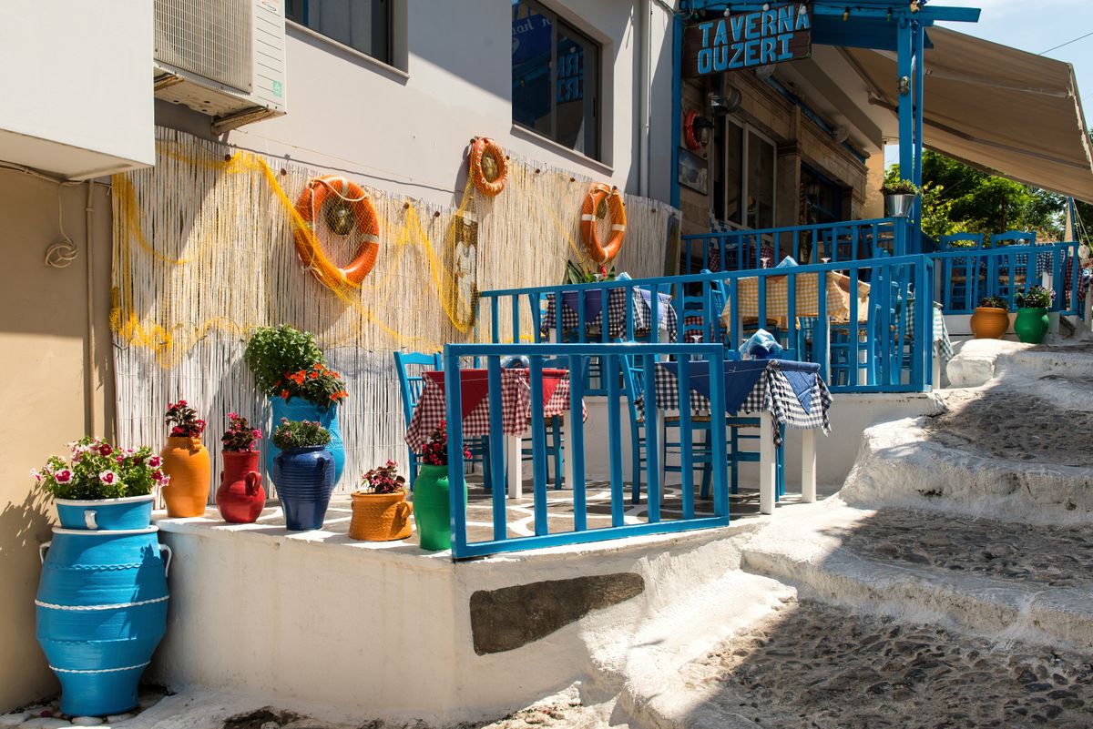 Traditional Greek taverna table set for dining with Mediterranean food and drinks