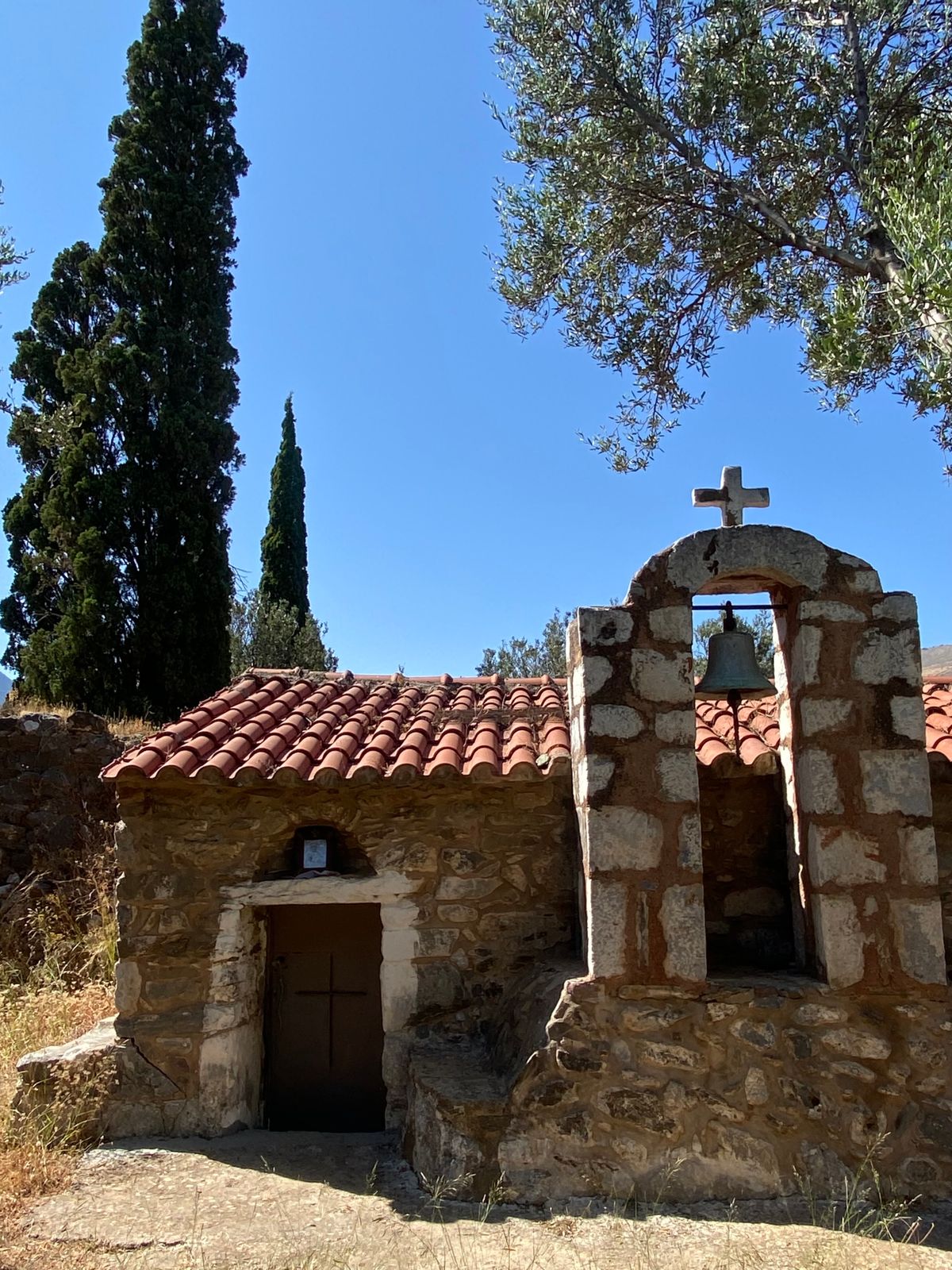 Traditional stone chapel with bell tower in the Mani Peninsula, Greece, against a clear sky