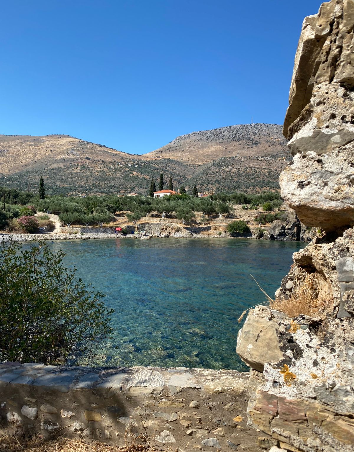 Gerolimenas fishing harbour in the Deep Mani with clear blue water and a mountainous backdrop