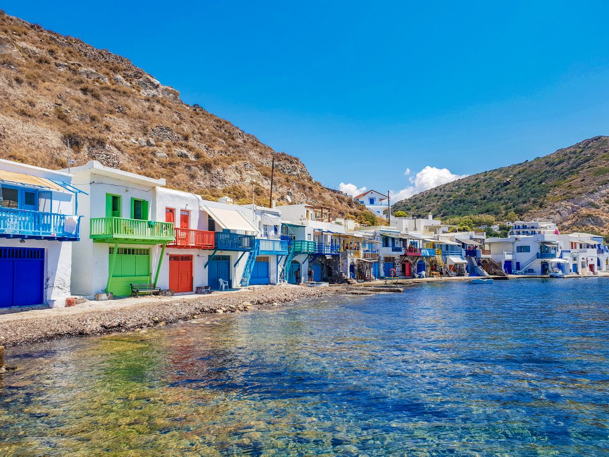 Row of colourful syrmata boathouses along the waterfront in Mandrakia fishing village, Milos, Greece