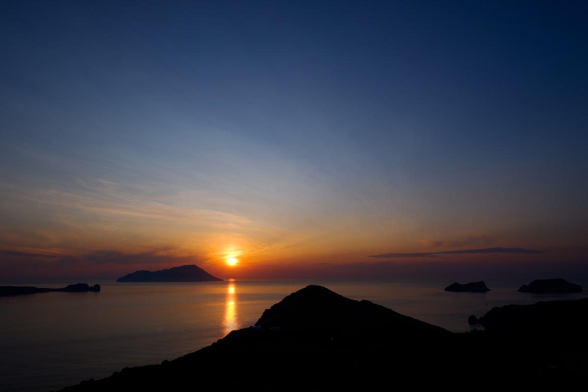 Sunset over the Aegean Sea viewed from the hilltop village of Plaka in Milos, Greece