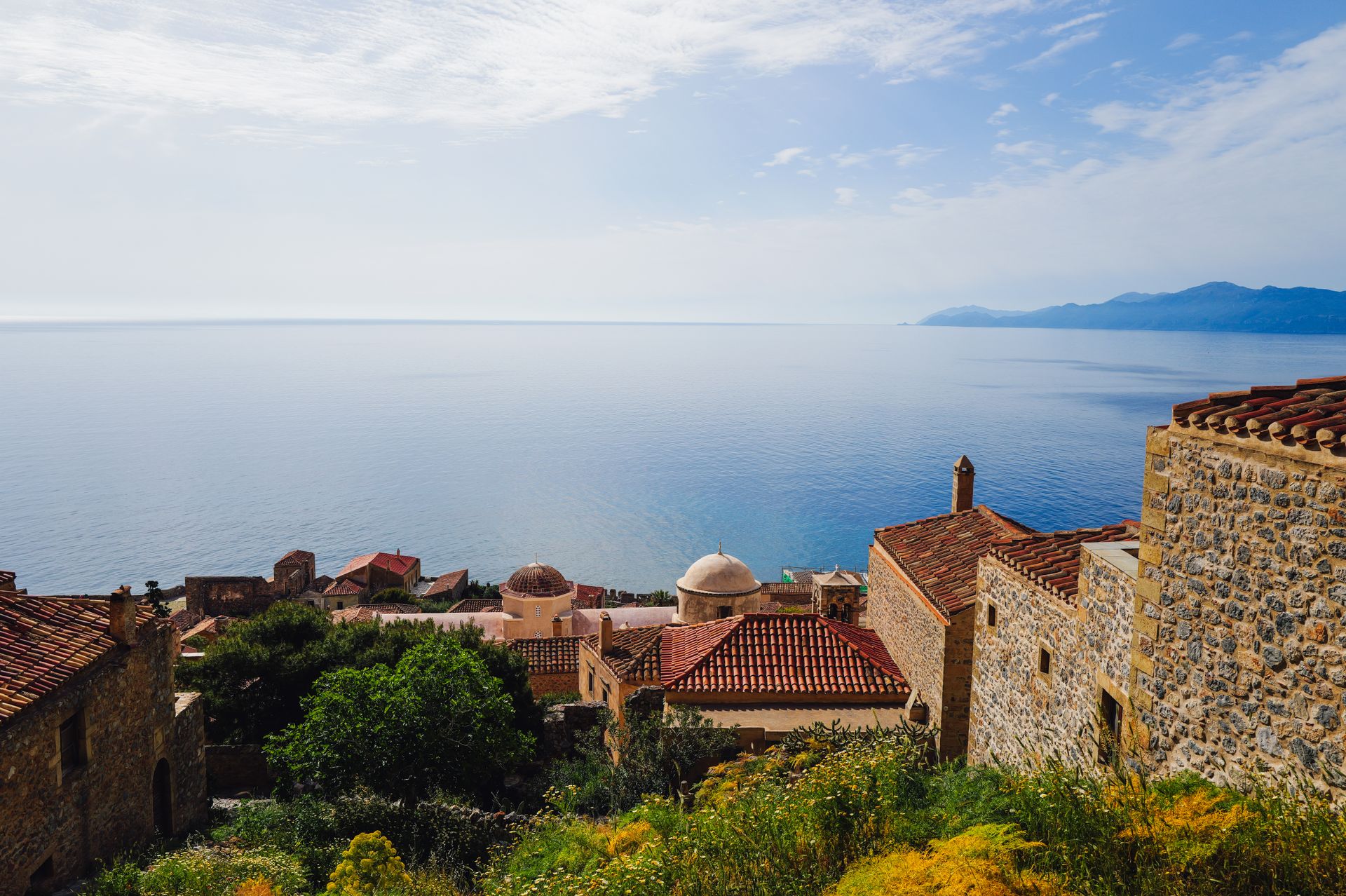 Monemvasia fortress rooftops descending toward the sea with the Aegean in the background