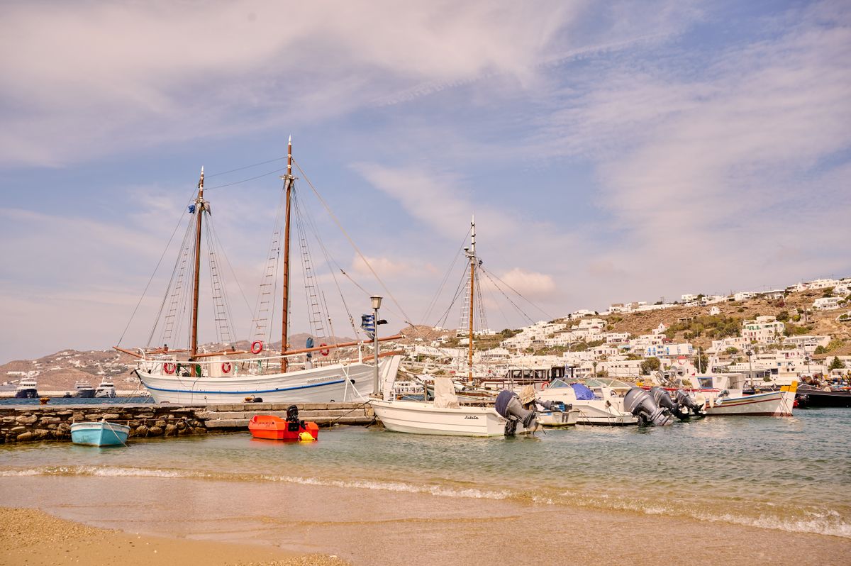 Sailboats and fishing boats moored in Mykonos harbour on a calm summer morning