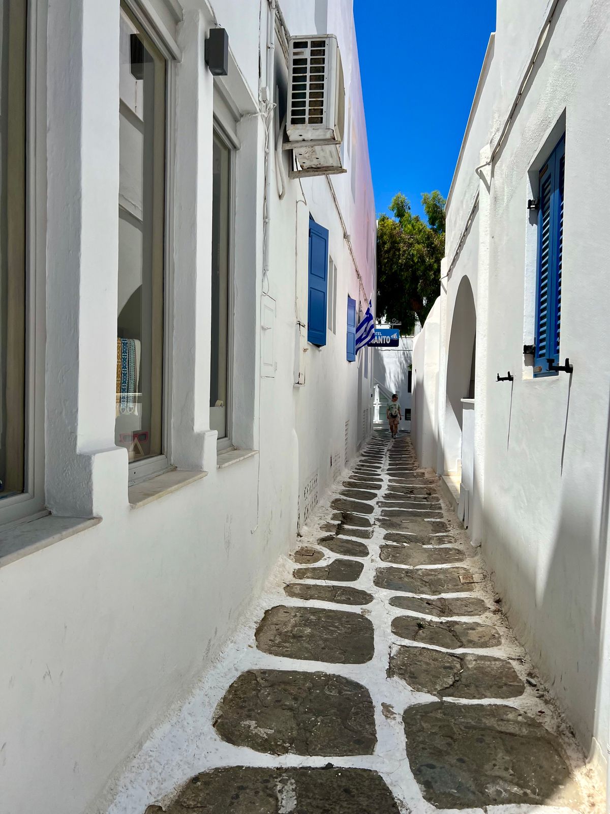 Narrow whitewashed street with blue accents in Mykonos Town Chora