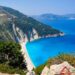 Aerial view of Myrtos Beach with turquoise waters and white pebble shore surrounded by limestone cliffs in Kefalonia, Greece