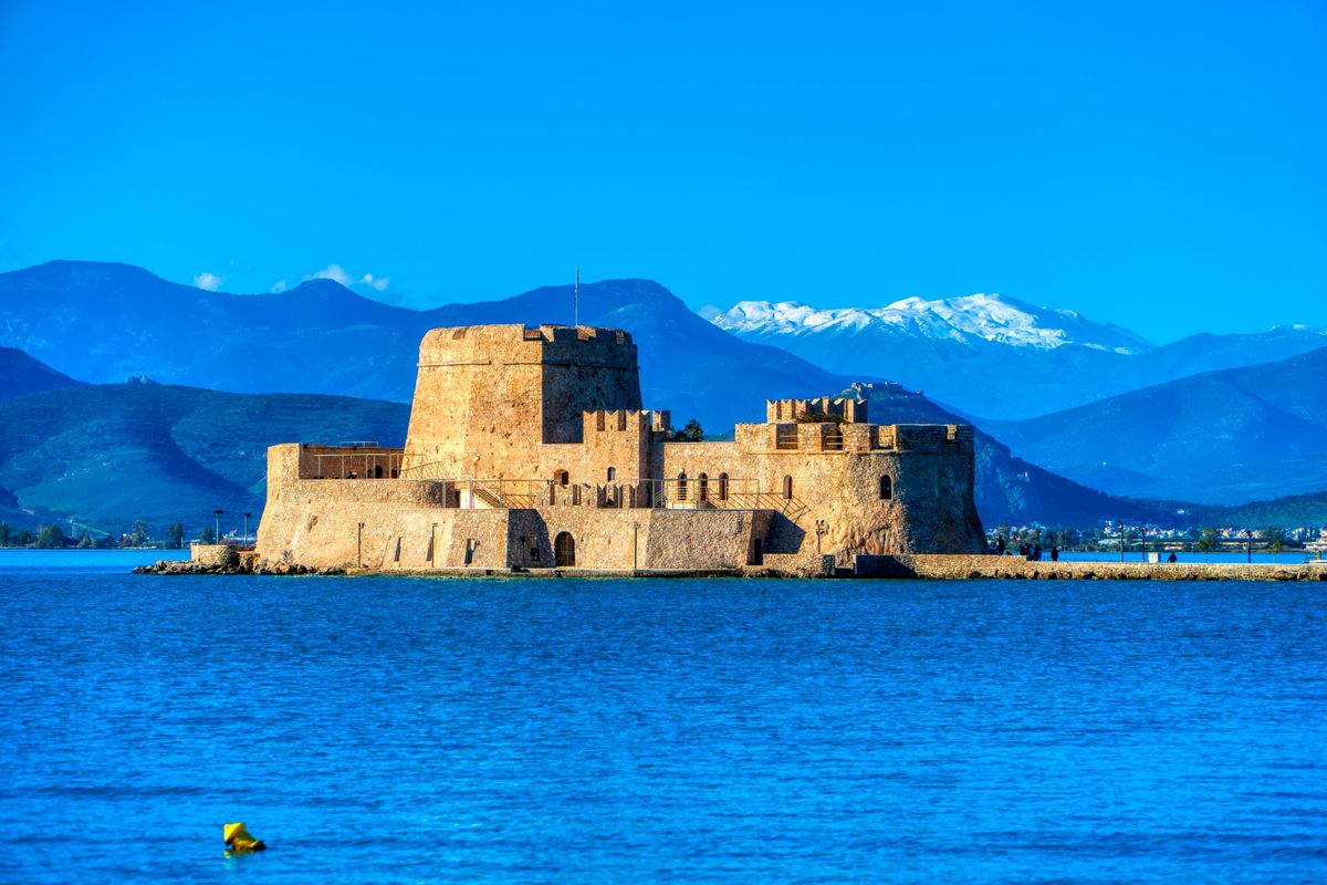 Bourtzi Castle in the harbour of Nafplio with the Argolic Gulf and mountains in the background