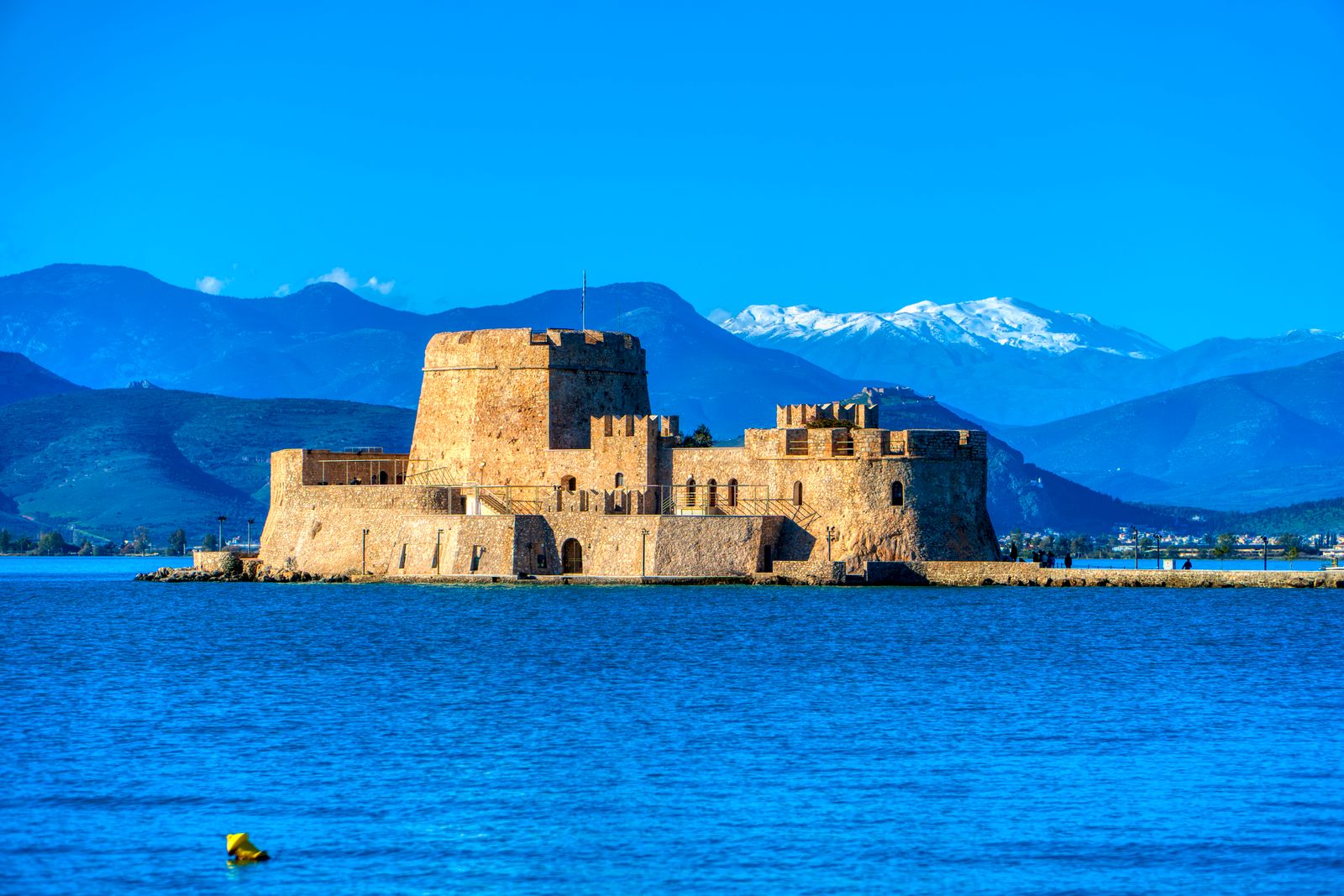 Bourtzi Castle in Nafplio harbour with mountains and sea in the background, Peloponnese Greece
