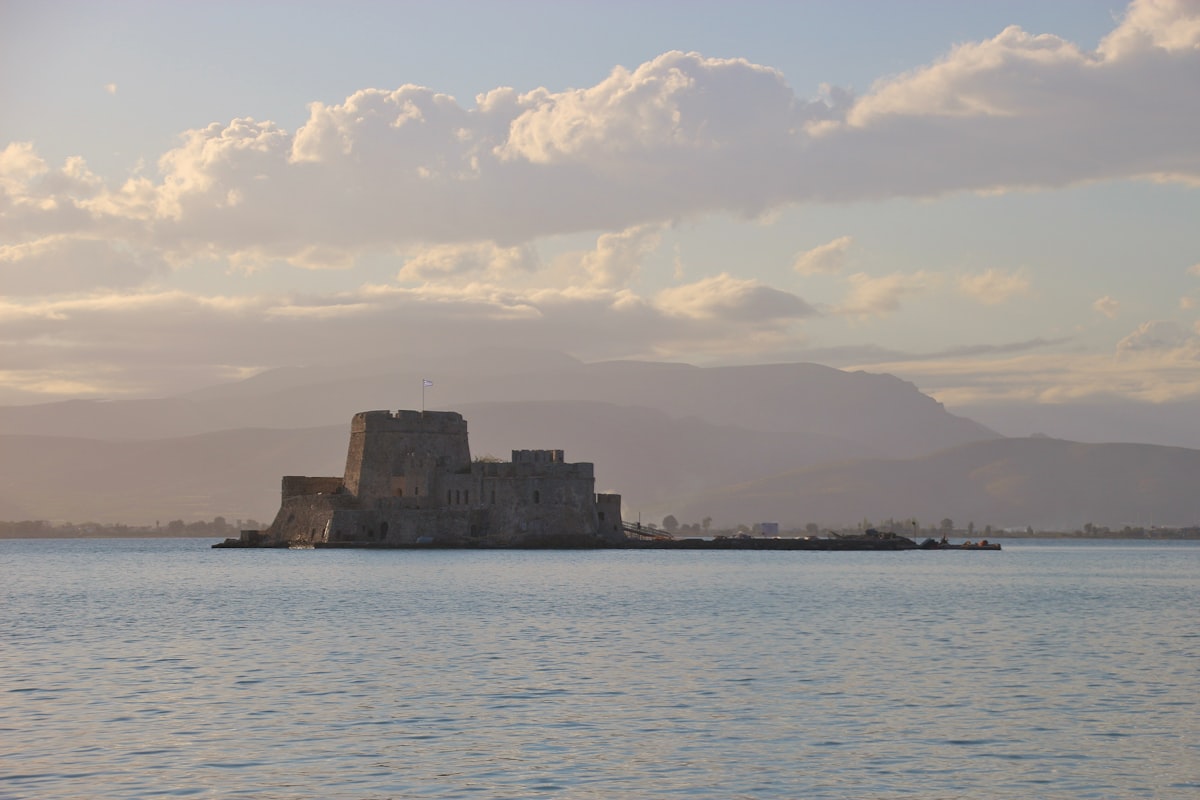 Bourtzi castle at sunset in the harbour of Nafplio, with the Argolic Gulf beyond