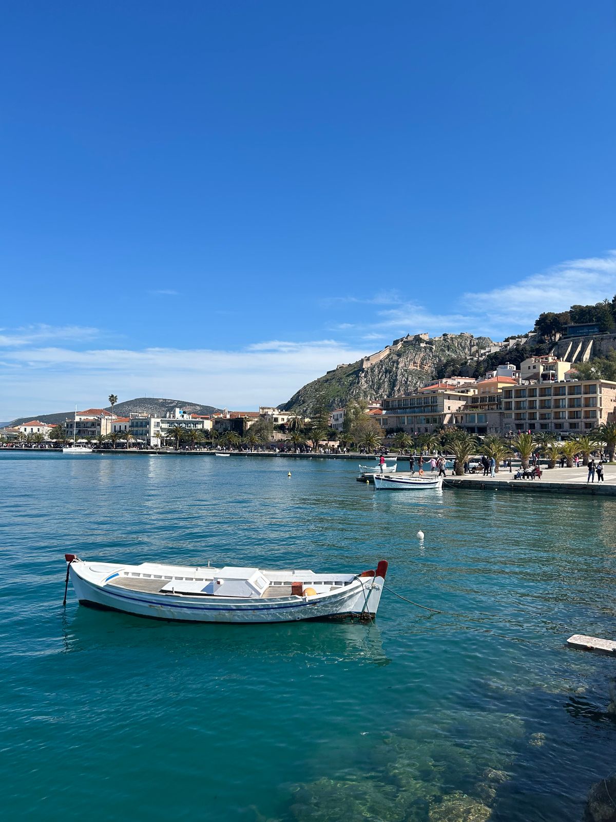 Nafplio harbour with traditional boats and waterfront buildings under a clear sky