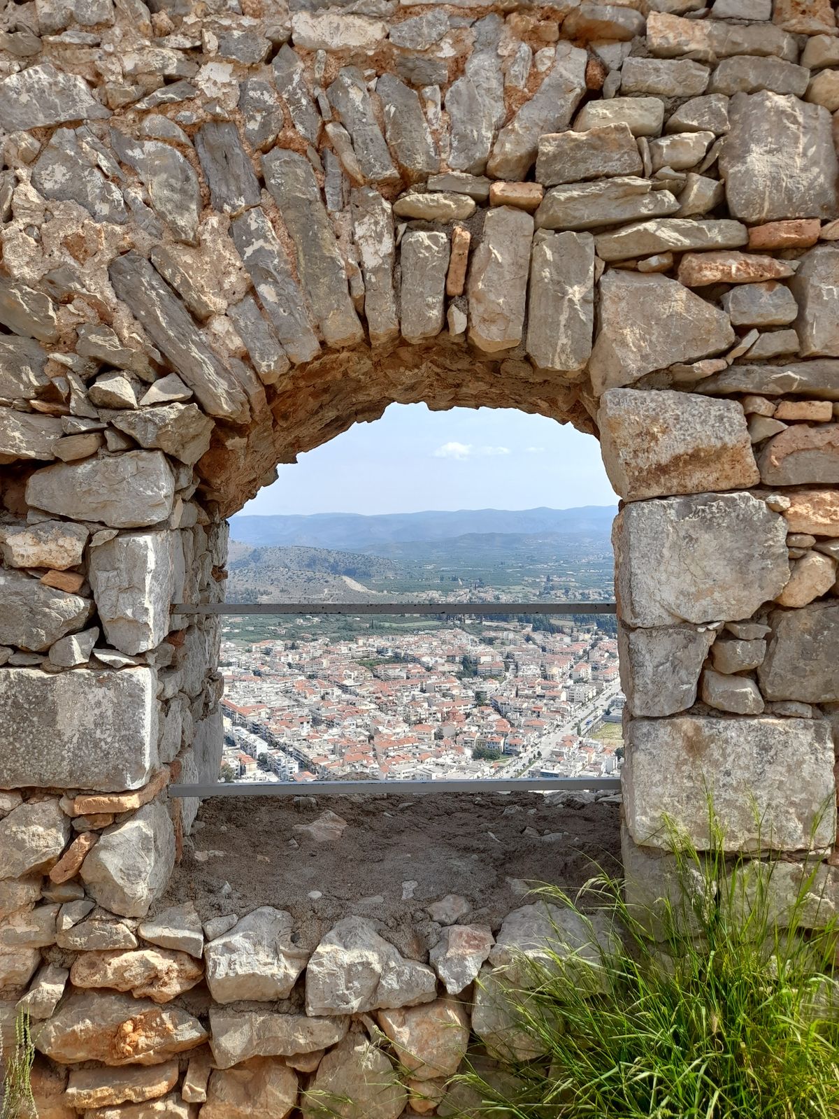 View of Nafplio through a stone archway inside Palamidi Fortress