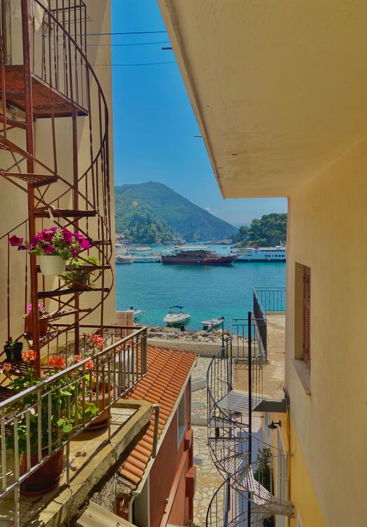 View of Parga harbour through a sunlit alley with flowers in the old town