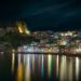 Parga harbour illuminated at night with colourful reflections on calm water