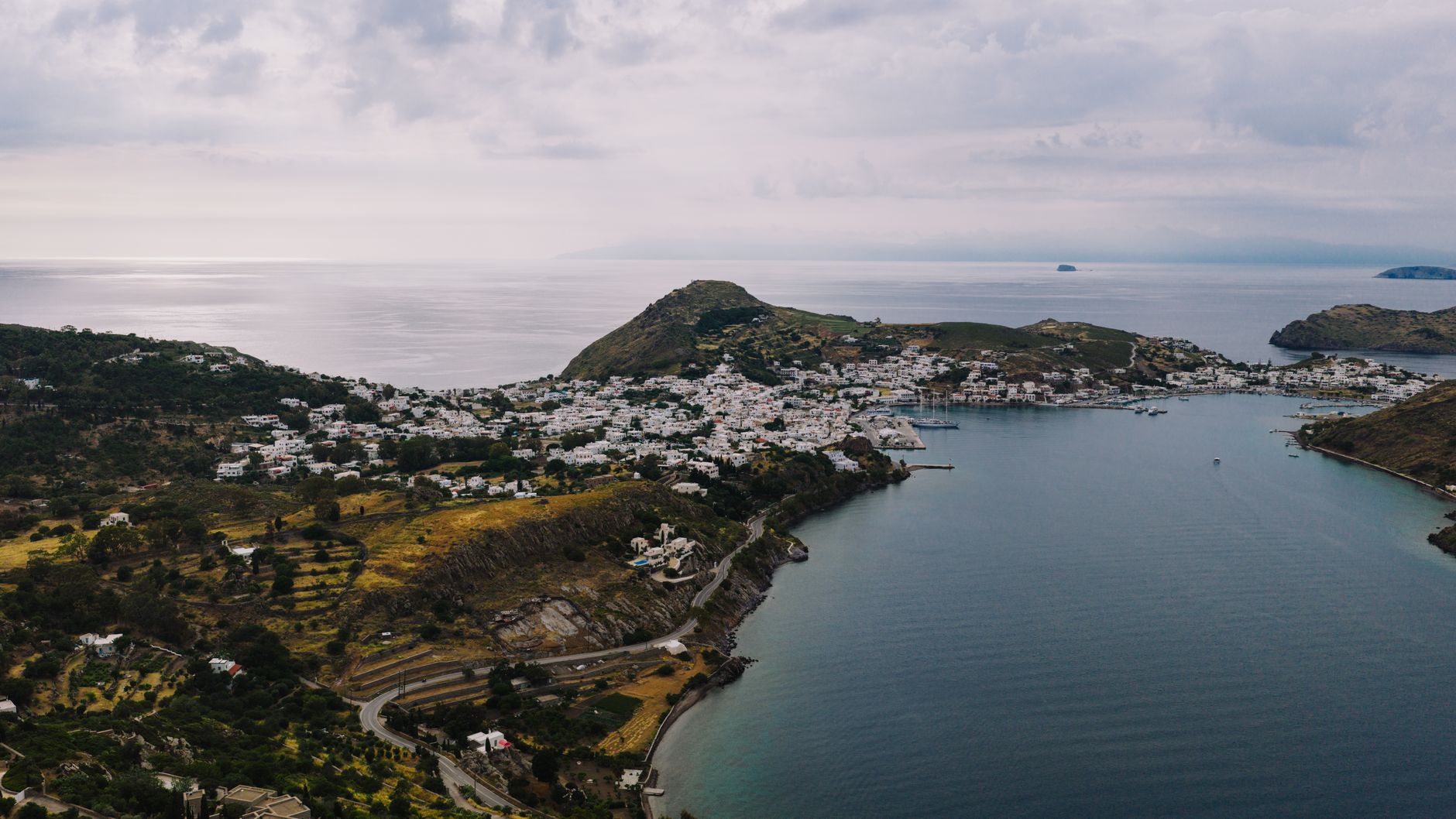 Aerial view of Patmos island coastline with traditional white buildings and blue Aegean Sea