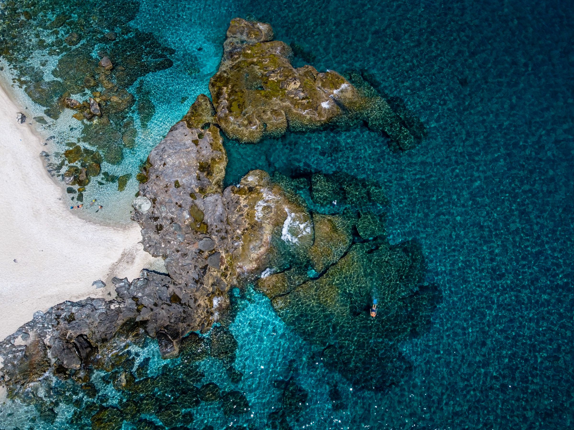 Aerial view of Plaka Beach in Pelion showing rocky formations and clear turquoise water