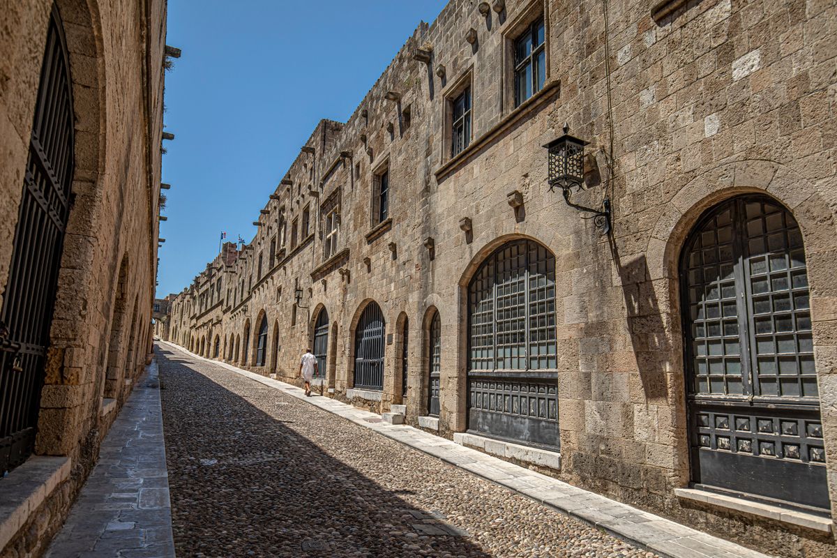 The cobblestone Street of the Knights in Rhodes Old Town, lined with medieval stone facades built by the Knights of St John