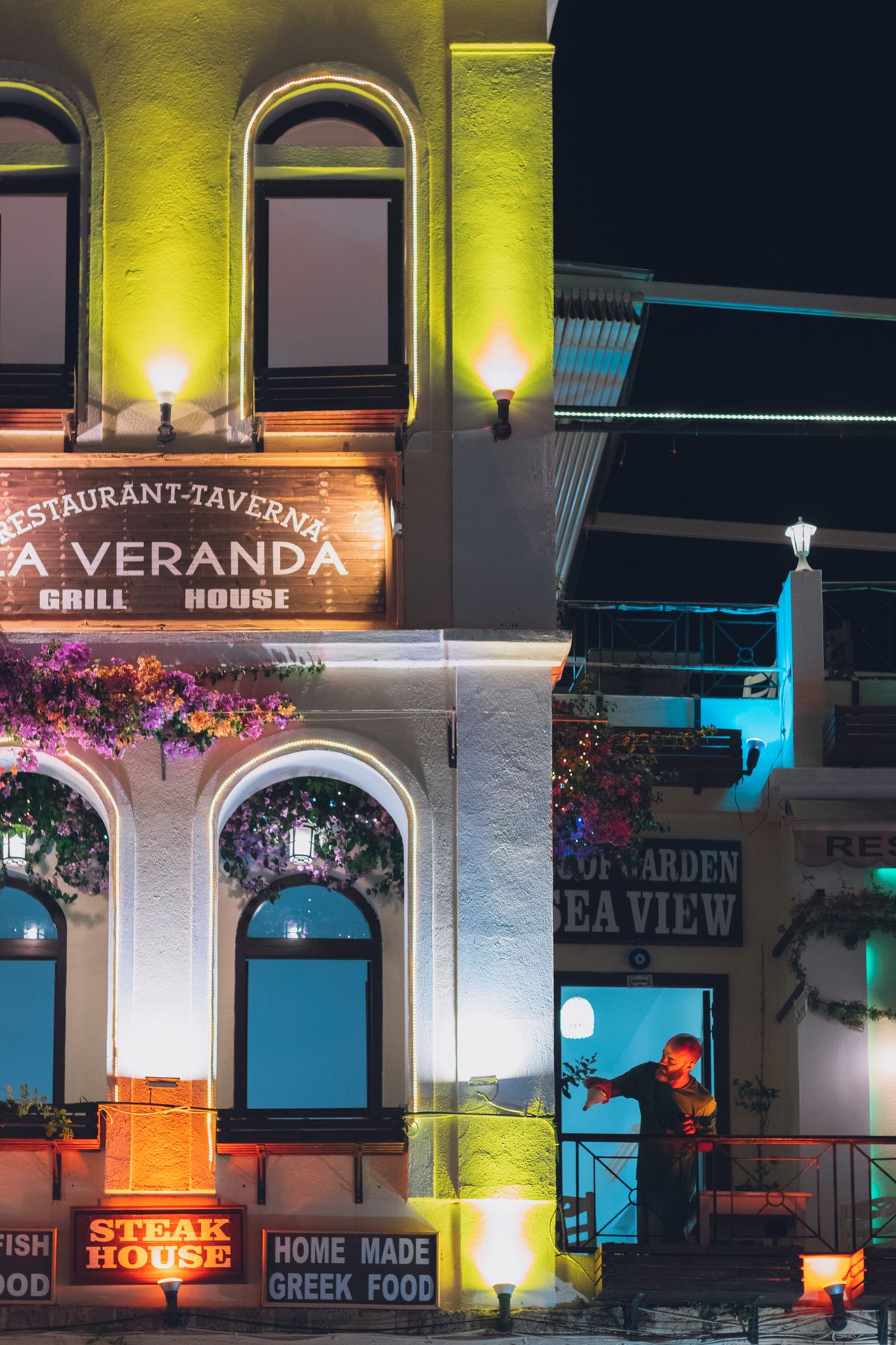 A colourfully illuminated taverna facade at night in Rhodes Old Town