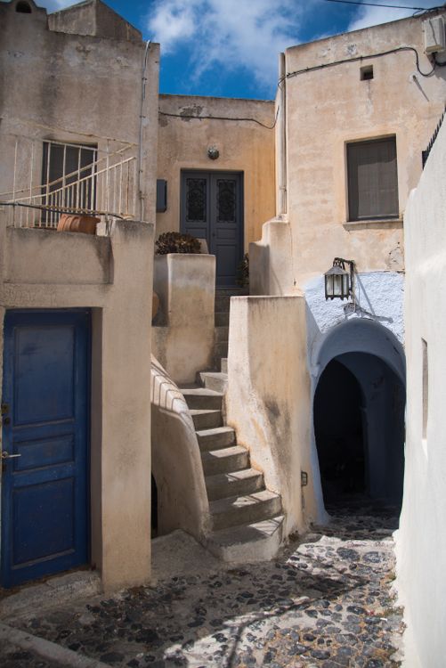 Traditional architecture with blue doors and stone staircase in Pyrgos Kallistis village, Santorini