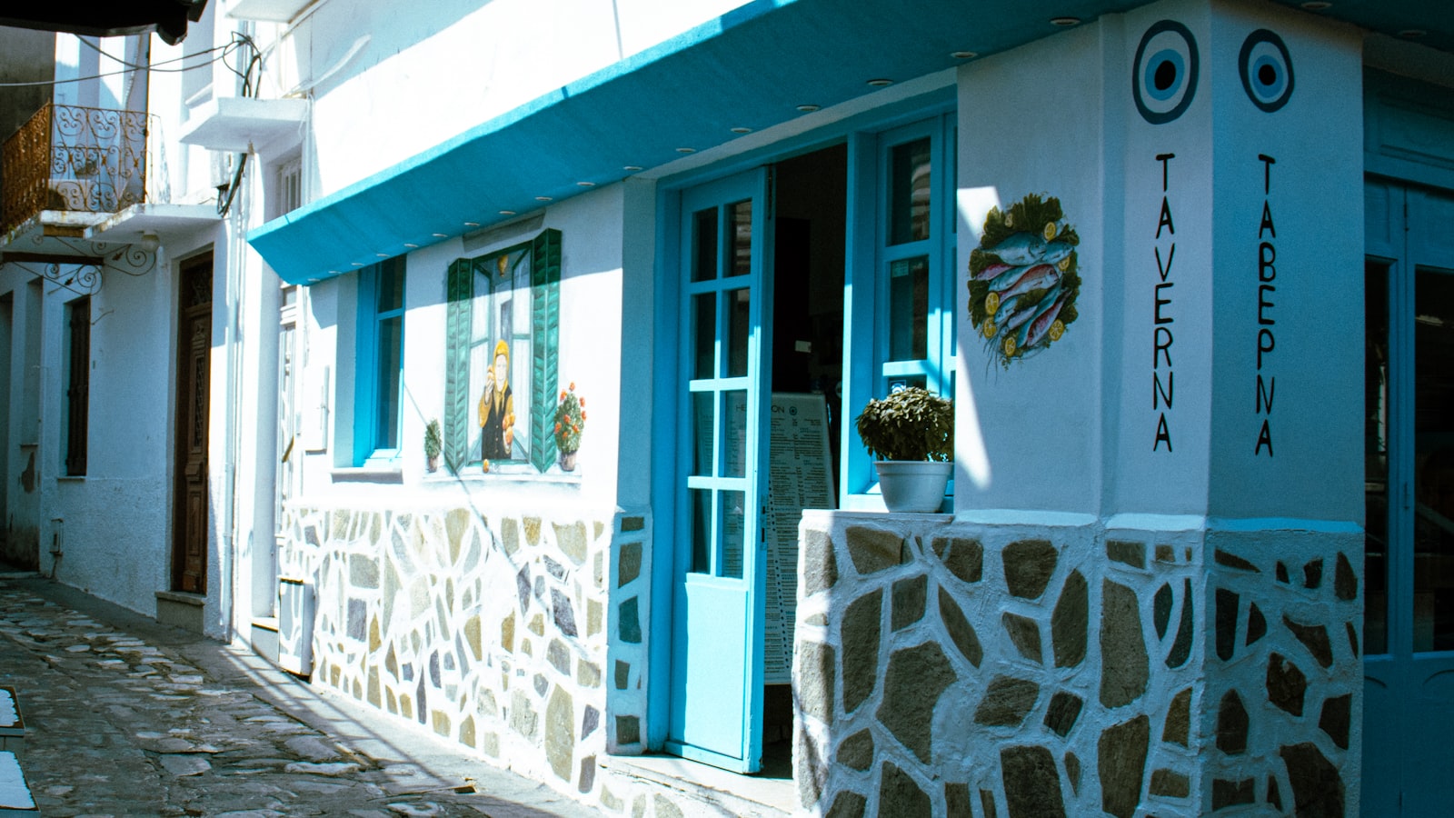 Outdoor taverna tables along a narrow lane in Skiathos Town