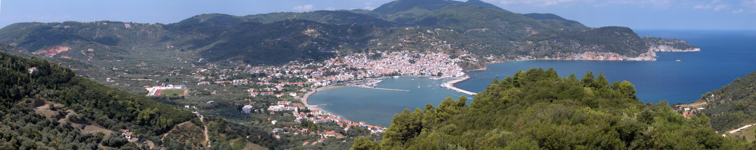 Panoramic view of Skopelos Chora town spread across the hillside above the harbour