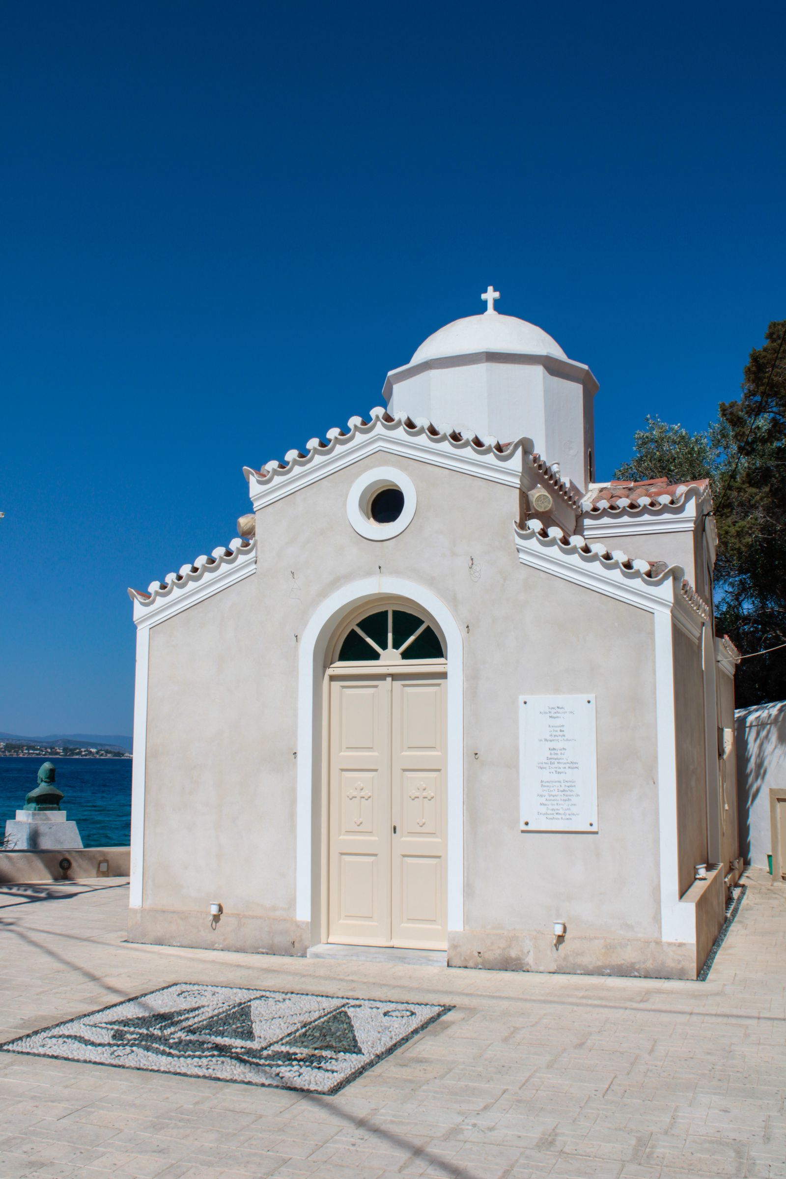 Orthodox church bell tower in Spetses town against a clear blue sky