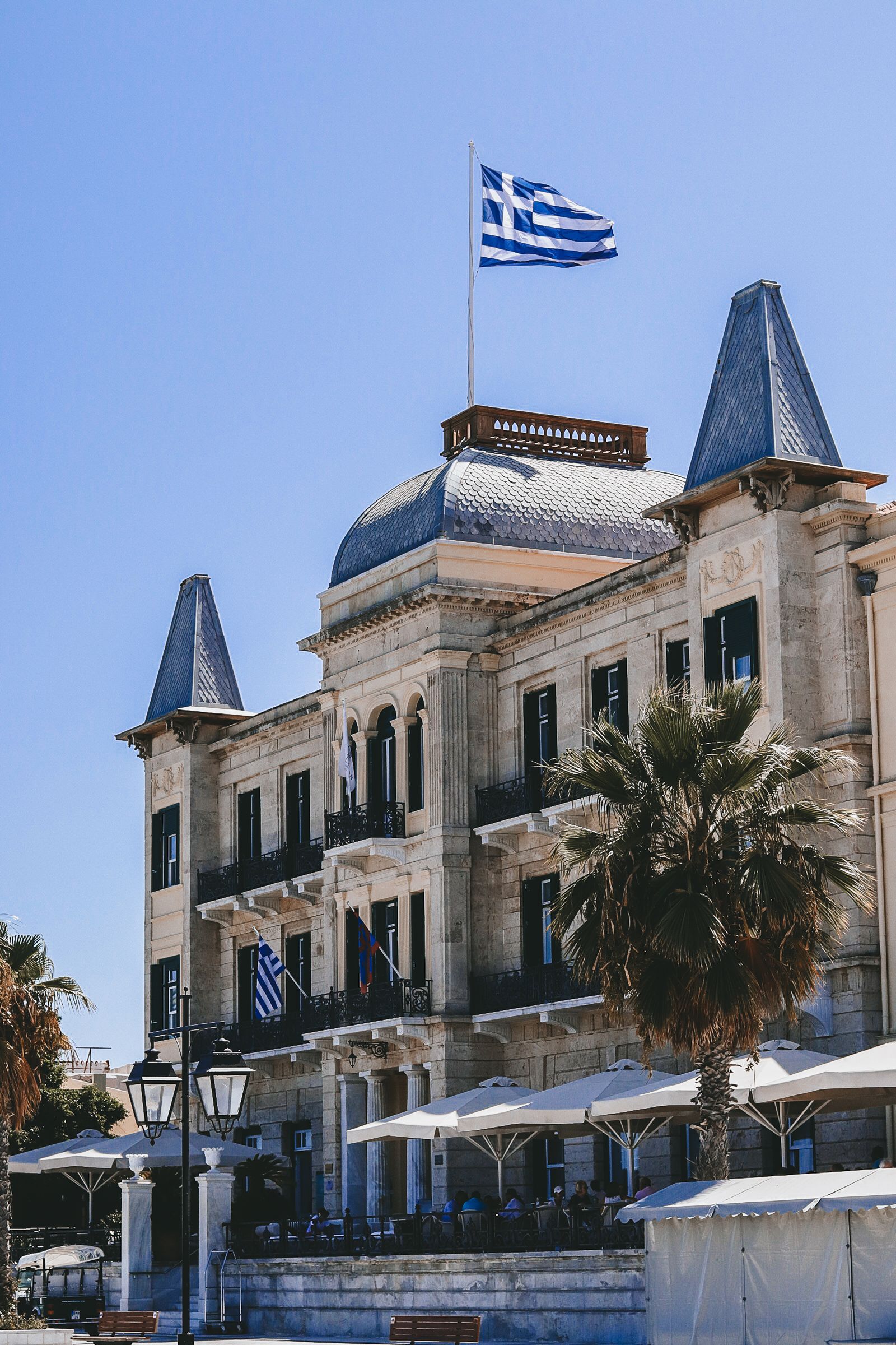 The Poseidonion Grand Hotel facade with Greek flag on the Spetses waterfront