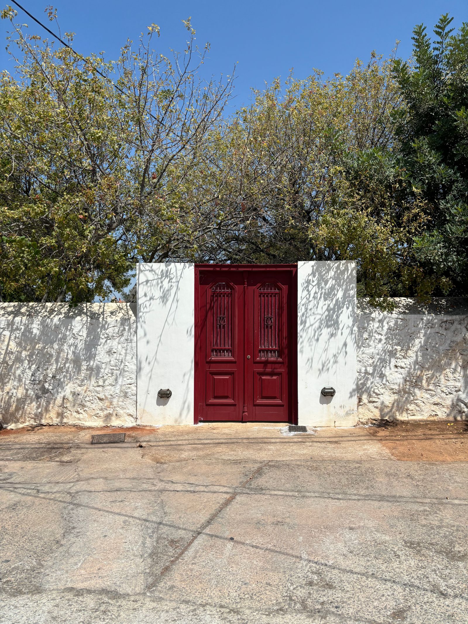 Traditional red door set in a white-washed wall on a Spetses side street
