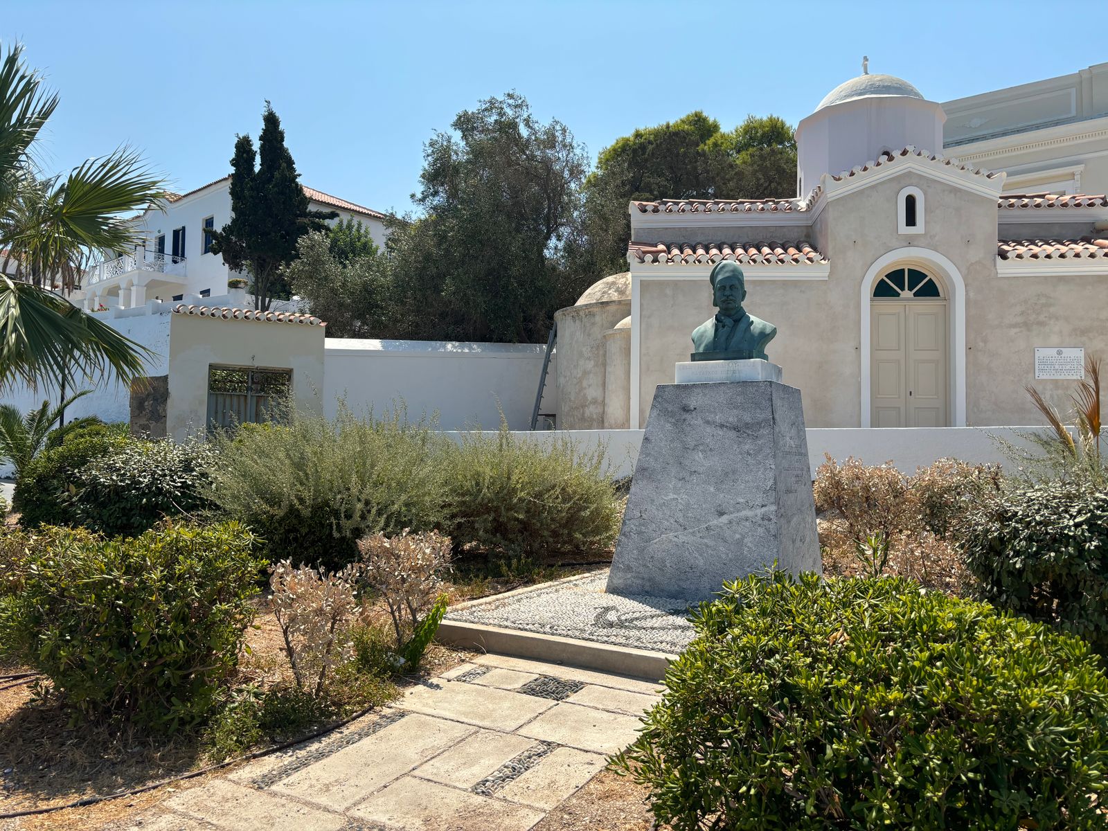 Bronze memorial bust in front of an Orthodox church in Spetses town Greece