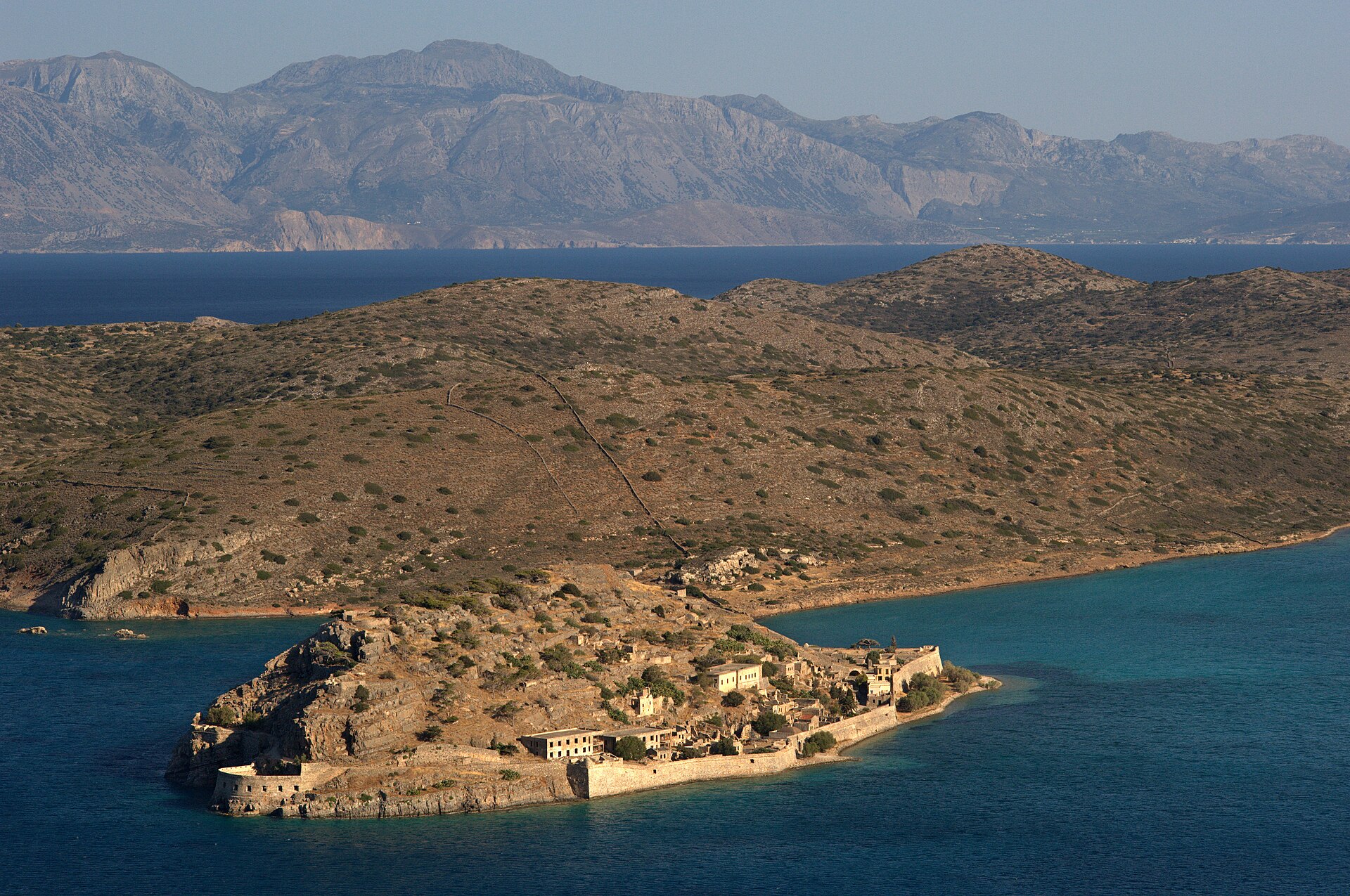 Aerial view of the fortified island of Spinalonga and the mountains beyond Elounda, Crete.